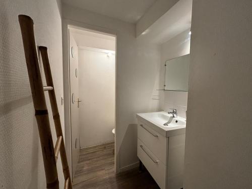 une salle de bain blanche avec un lavabo et un miroir dans l'établissement La Petite Bastide, à Carcassonne