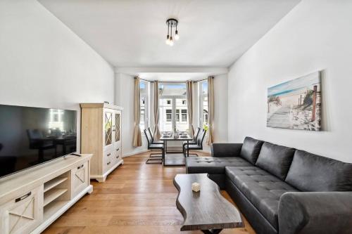 a living room with a couch and a table at Infinity Stay Ferienapartments Rheinstrasse in Wilhelmshaven