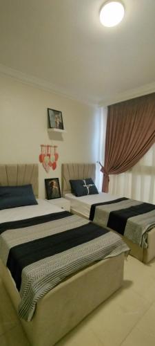 Un dormitorio con dos camas en una habitación. en The Location - Luxury apartments in cairo, en El Cairo