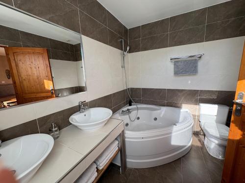 a bathroom with two sinks and a tub and a toilet at GuestHouse Le Patio34 in Lavérune
