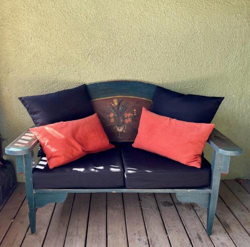 a blue couch with four red pillows sitting against a wall at Boho Loft in Downtown Wakefield in Wakefield