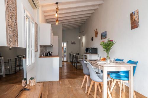 une cuisine et une salle à manger avec une table et des chaises dans l'établissement Le Bougainvillier Menton Vieille Ville, à Menton