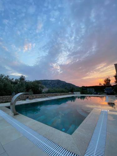 BrežaniにあるVilla Nikaの夕日を背景にしたプール