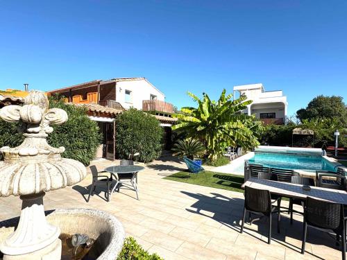 un patio avec une fontaine et une piscine dans l'établissement Gites Le Patio34, à Lavérune