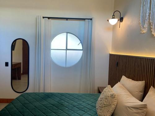 a bedroom with a bed and a round window at Hotel Ojo de Agua in Ciudad Hidalgo