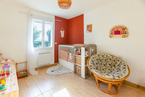 - une chambre bébé avec un lit bébé et une chaise haute dans l'établissement Villa t4 à la campagne, à Belleserre