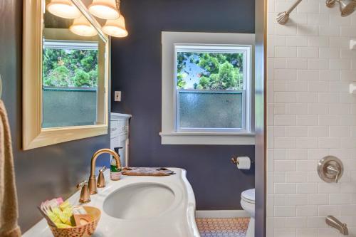 a bathroom with a sink and a toilet and two windows at Casa Blanca in Napa