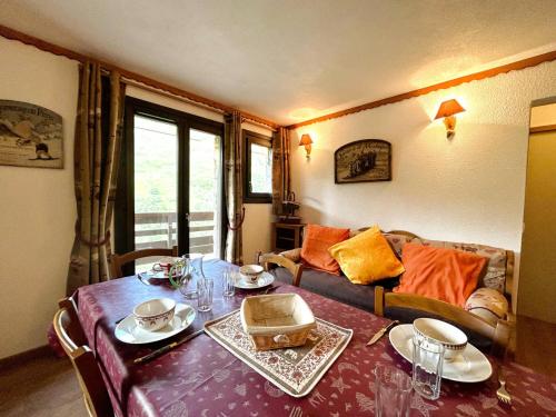 un salon avec une table et un canapé dans l'établissement Résidence Balcons D'olympie - Appartement chaleureux avec vue sur les pistes MAE-0721, aux Menuires