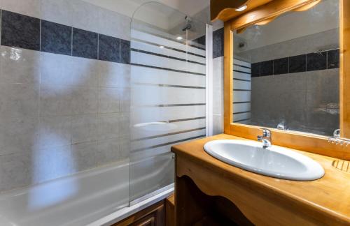 une salle de bain avec un lavabo, une baignoire et un miroir dans l'établissement Résidence Les Hauts De Preclaux - Appartement avec 2 chambres aux Orres 1800 MAE-8241, aux Orres