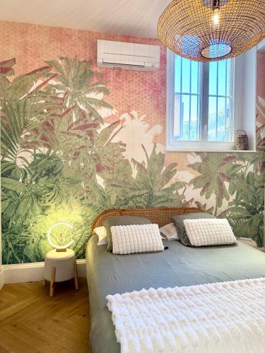 - une chambre avec un lit orné d'une fresque murale de palmiers dans l'établissement Appartement de luxe à deux pas des Halles, quai Valliere, à Narbonne