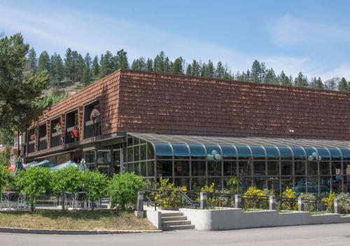 a brown brick building with a balcony and plants at Tonquin Inn in Jasper