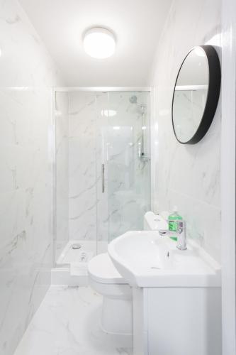 a white bathroom with a sink and a shower at Studio9 Rooms in London