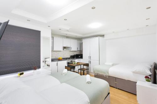a hotel room with two beds and a kitchen at Studio9 Rooms in London