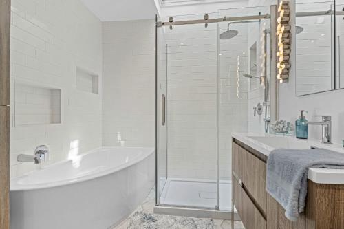 a white bathroom with a tub and a shower at Large Beautiful 2BR Apartment fully equipped in Montréal