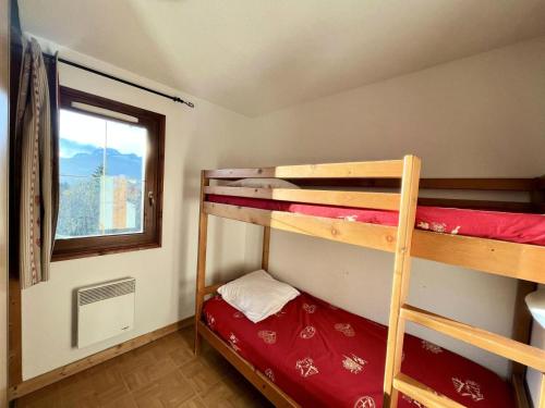 Cette petite chambre dispose de 2 lits superposés et d'une fenêtre. dans l'établissement Les Chalets Des Evettes - Résidence avec piscine au pied des pistes MAE-0611, à Flumet