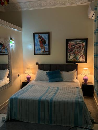 a bedroom with a large bed with two lamps at Paradise house in Marrakech