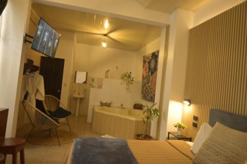 a bedroom with a bed and a bathroom with a tub at Hotel Las Colinas in Fortuna