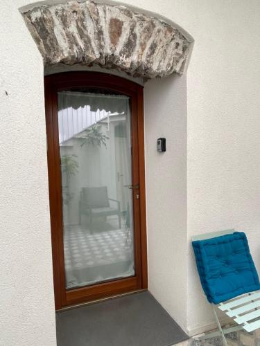 a door with a window and a blue chair at Sa Troppa de sos chentu in Dorgali