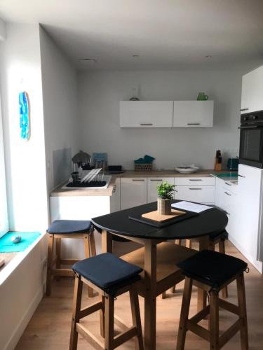 - une cuisine avec une table et quatre chaises dans l'établissement Appartement neuf près de la plage, à Fouesnant