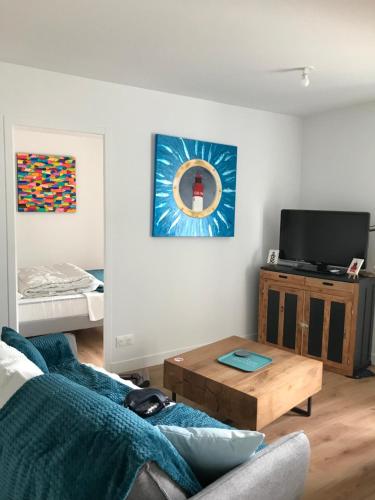 un salon avec un canapé et une table dans l'établissement Appartement neuf près de la plage, à Fouesnant