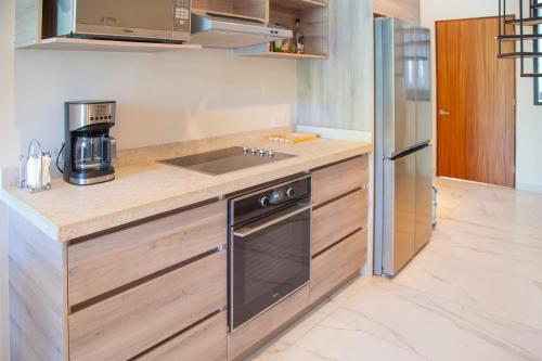 a kitchen with a sink and a stove at HOTEL BIULÚ in Santa Cruz Huatulco