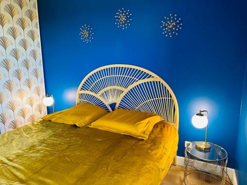 une chambre avec un grand lit avec un mur bleu dans l'établissement You&Me, à Narbonne