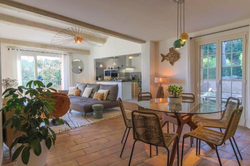 un salon avec une table, des chaises et un canapé dans l'établissement Penthouse La Vigie, à Cavalaire-sur-Mer