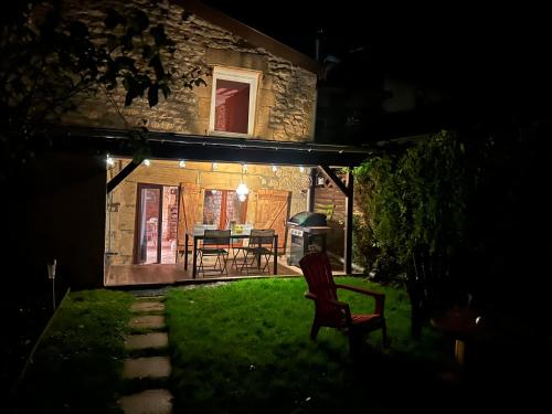 a backyard at night with a table and chairs at GITE LA LOUTRE in Stenay