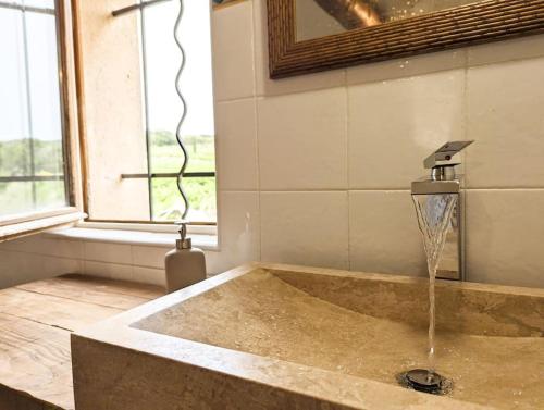 a bathroom with a tub with a water fountain at Le Mas de mon Père in Villedieu