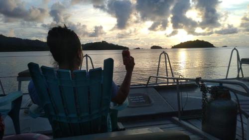 a woman sitting in a chair on a boat on the water at Hostal Portobelo in Portobelo