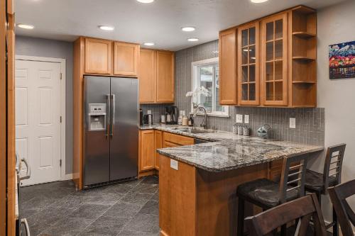 a kitchen with wooden cabinets and a stainless steel refrigerator at Cozy City Stay, 3bdrm near Airport in Anchorage