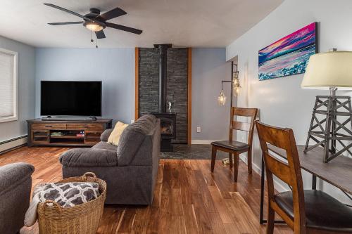 a living room with a tv and a couch and chairs at Cozy City Stay, 3bdrm near Airport in Anchorage