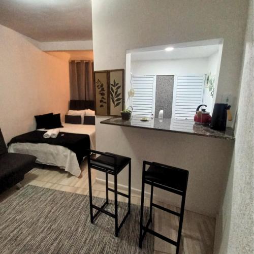 a living room with two chairs and a bed at Apêzinho Vidigal - RJ in Rio de Janeiro