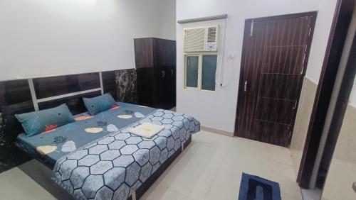 a bedroom with a bed and a small door at Spiritual Apartment in Vrindāvan
