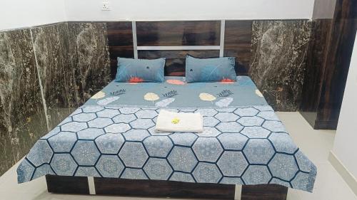 a bedroom with a bed with blue comforter at Spiritual Apartment in Vrindāvan