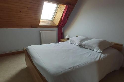 a bedroom with a white bed with a window at Domaine des Lauriers 20 couchages in Languidic