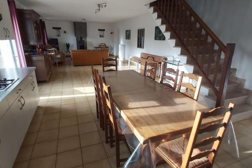 a kitchen with a table and chairs and a staircase at Domaine des Lauriers 20 couchages in Languidic