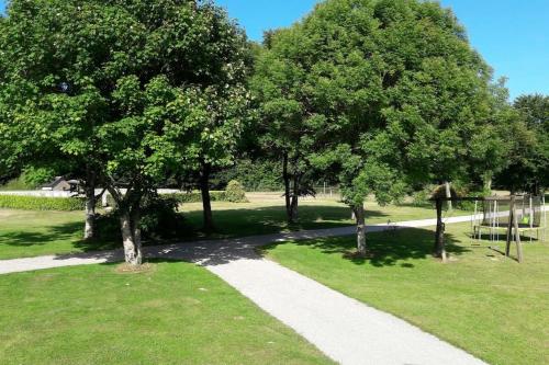 a walkway in a park with trees and grass at Domaine des Lauriers 20 couchages in Languidic