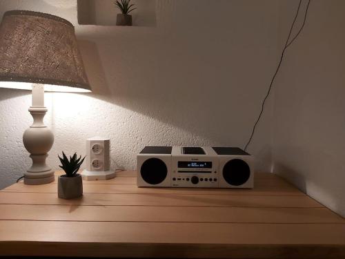 a radio sitting on a table next to a lamp at Domaine des Lauriers 20 couchages in Languidic