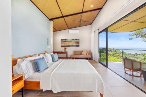 a bedroom with a bed and a view of the ocean at Hotel Three Sixty - Adults Only in Ojochal