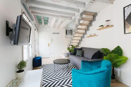 un salon avec un canapé et un escalier dans l'établissement Central Appartement - Sentier, à Paris