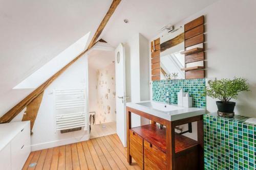 - une salle de bains mansardée pourvue d'un lavabo dans l'établissement Central Appartement - Sentier, à Paris