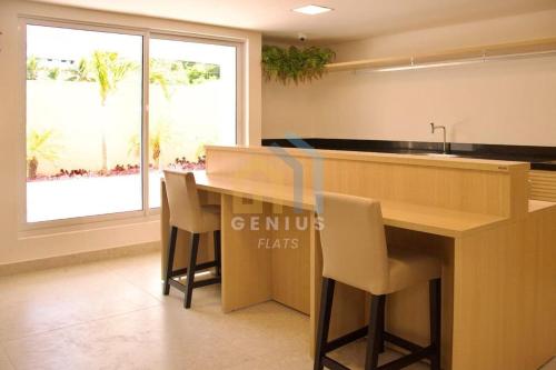 a kitchen with a counter with chairs and a sink at Puerto Ventura Cabo Branco Genius Flats in João Pessoa