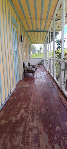 an empty porch with two benches on a house at Refugio Paramo Trek Murillo in Murillo