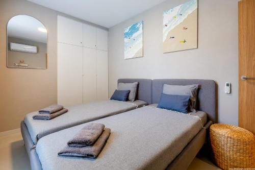 two beds in a small room with blue pillows at Stylish family home in Los Gigantes in Santiago del Teide