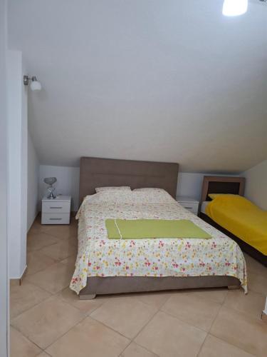 a bedroom with a bed with a green comforter at Apartments Pejanović in Kotor