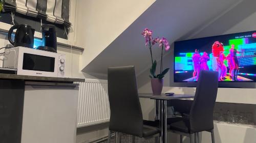 a kitchen with a table with chairs and a television at Ferienwohnung Bina in Trier
