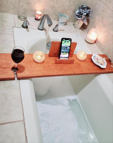 a cell phone sitting on a wooden tray in a bath tub at Casa de Wen in Santa Rita