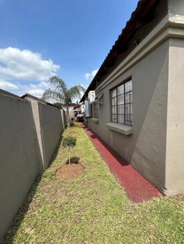 a house with a red sidewalk next to a building at 3 Bed home Nelspruit Golden Crescent in Nelspruit