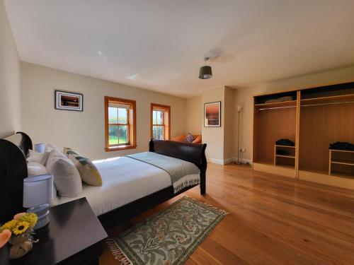 a bedroom with a large bed and wooden floors at Reeks Country House in Killarney